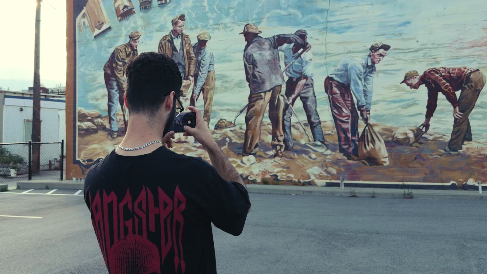 A visitor holding a phone up to the Trail mural, watching the flood come alive.